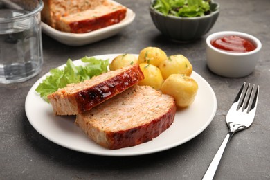 Photo of Delicious baked turkey meatloaf with potatoes served on grey table, closeup