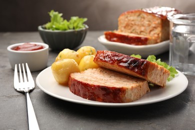 Photo of Delicious baked turkey meatloaf with potatoes served on grey table, closeup