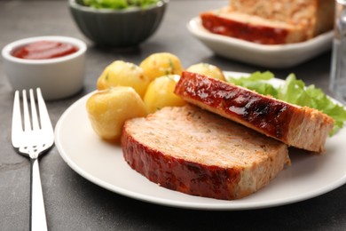 Photo of Delicious baked turkey meatloaf with potatoes served on grey table, closeup