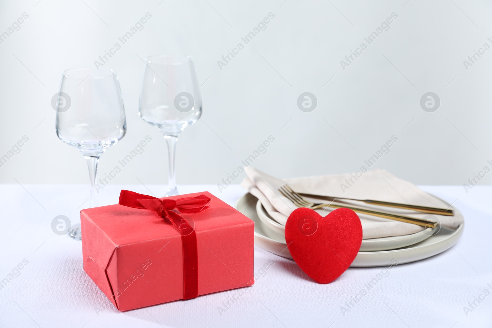 Photo of Gift and setting for romantic dinner on white background