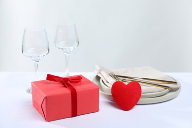 Photo of Gift and setting for romantic dinner on white background