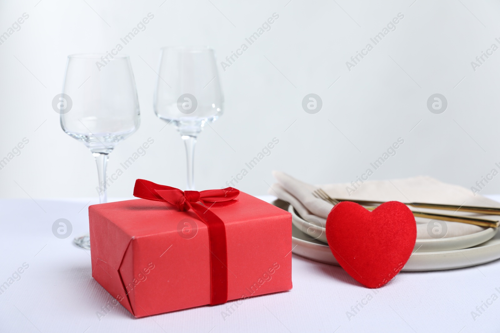 Photo of Gift and setting for romantic dinner on white background