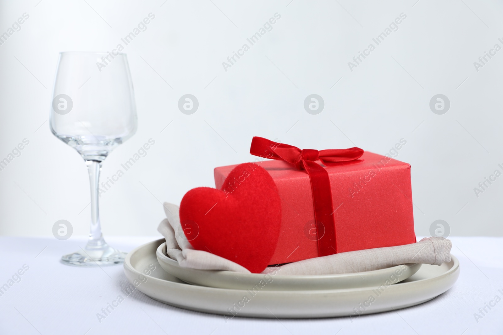 Photo of Gift and setting for romantic dinner on white background