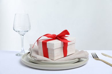 Photo of Gift and setting for romantic dinner on white background