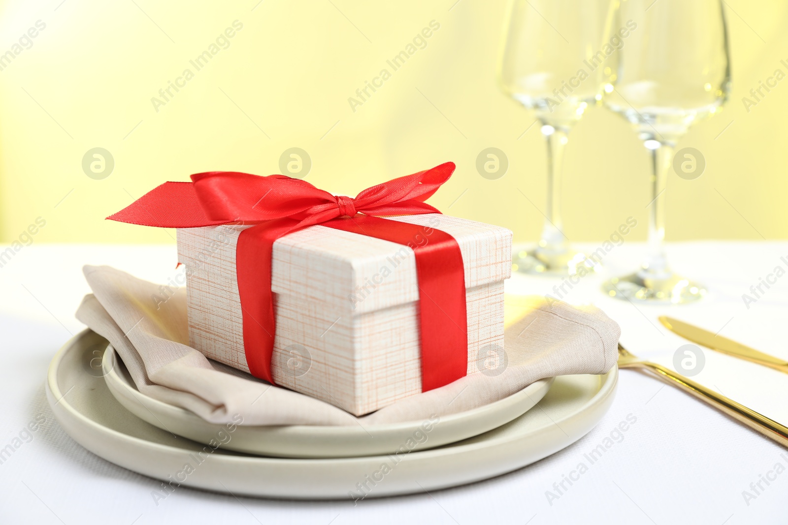 Photo of Gift and setting for romantic dinner on white background, closeup