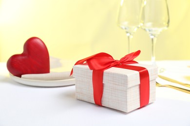 Photo of Gift and setting for romantic dinner on white background, closeup