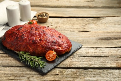 Photo of Delicious turkey meatloaf with tomato and rosemary on wooden table. Space for text