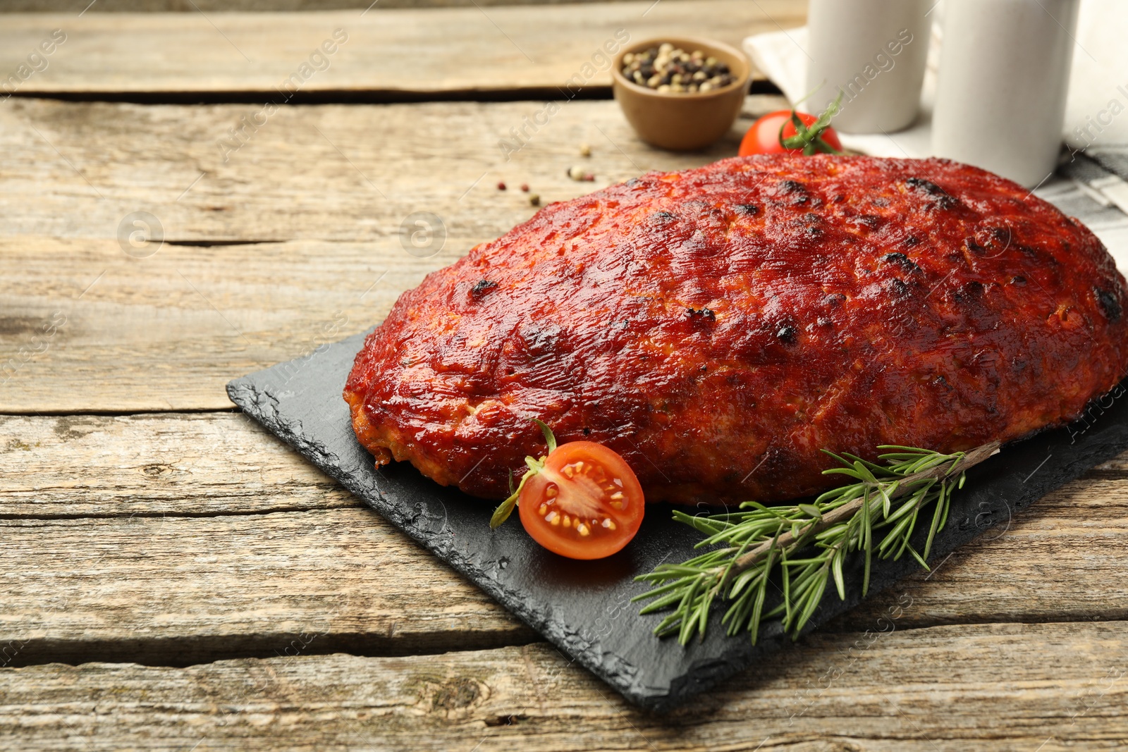 Photo of Delicious turkey meatloaf with tomatoes and rosemary on wooden table. Space for text