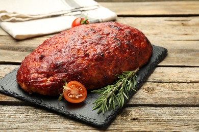 Photo of Delicious turkey meatloaf with tomatoes and rosemary on wooden table