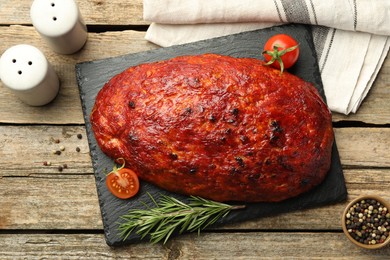 Photo of Delicious turkey meatloaf with tomatoes and rosemary on wooden table, top view