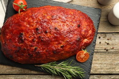 Photo of Delicious turkey meatloaf with tomatoes and rosemary on wooden table, top view