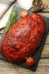 Photo of Delicious turkey meatloaf with tomatoes and rosemary on wooden table, top view