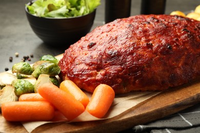 Photo of Delicious turkey meatloaf with vegetables on grey table, closeup