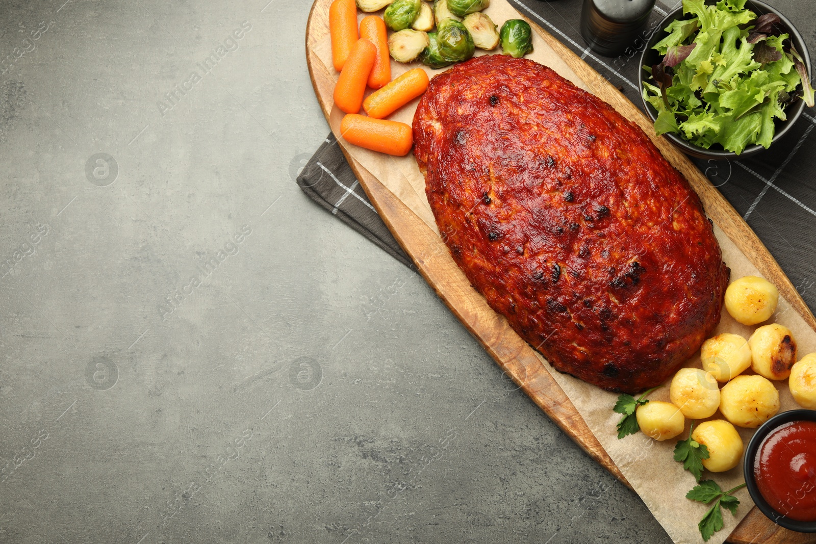 Delicious turkey meatloaf with vegetables on grey table, top view. Space for text Photo of Delicious turkey meatloaf with vegetables on grey table, top view. Space for text