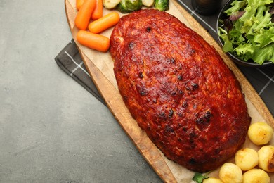 Photo of Delicious turkey meatloaf with vegetables on grey table, top view. Space for text