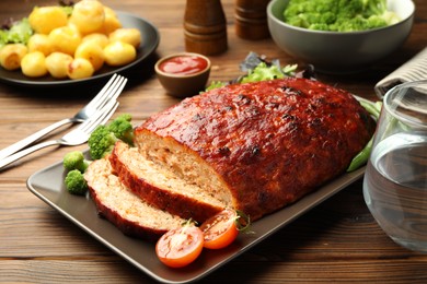 Photo of Delicious turkey meatloaf with vegetables on wooden table