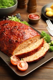 Photo of Delicious turkey meatloaf with vegetables on wooden table