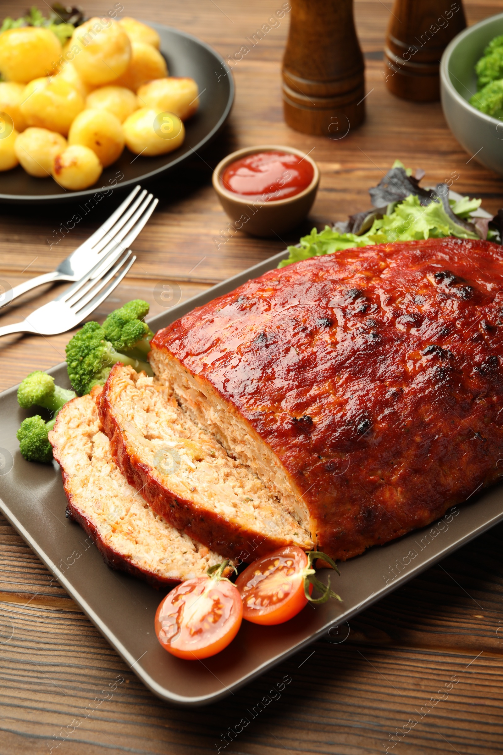 Photo of Delicious turkey meatloaf with vegetables on wooden table