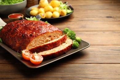 Photo of Delicious turkey meatloaf with vegetables on wooden table. Space for text