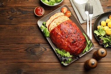 Photo of Delicious turkey meatloaf with vegetables served on wooden table, flat lay. Space for text