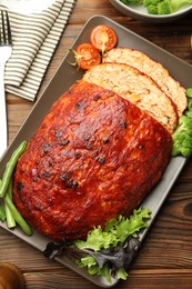 Photo of Delicious turkey meatloaf with vegetables served on wooden table, flat lay