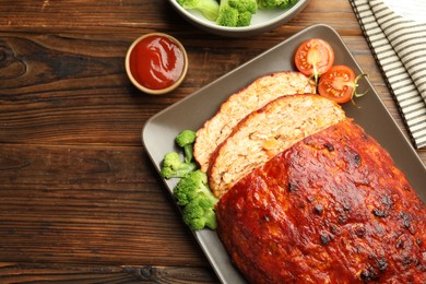 Delicious turkey meatloaf with vegetables on wooden table, flat lay. Space for text