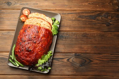 Photo of Delicious turkey meatloaf with vegetables on wooden table, top view. Space for text