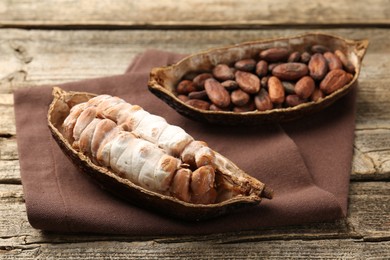 Cocoa pods with beans on wooden table, closeup