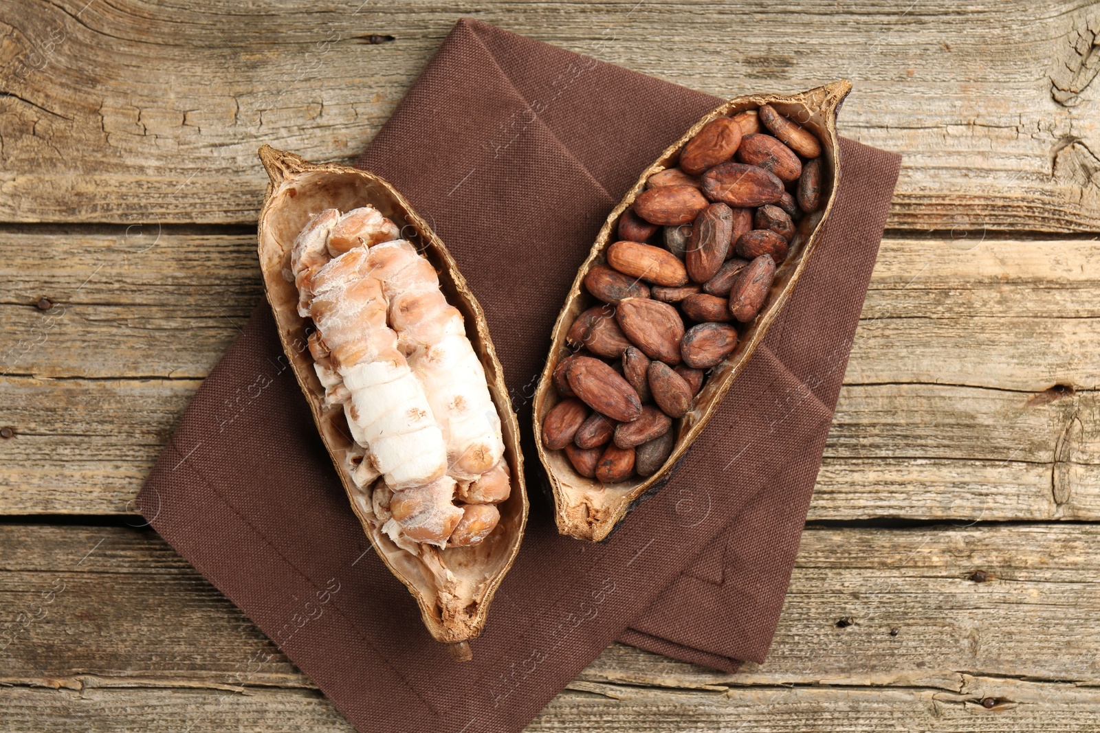 Photo of Cocoa pods with beans on wooden table, top view