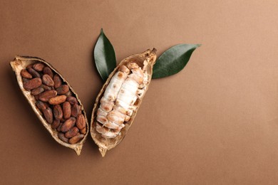 Cocoa pods with beans on brown background, top view. Space for text