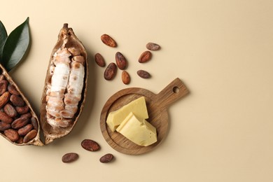 Cocoa pods with beans and butter on beige background, flat lay. Space for text