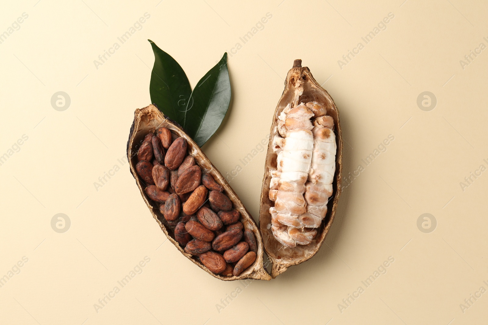 Photo of Cocoa pods with beans on beige background, top view