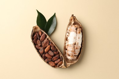 Cocoa pods with beans on beige background, top view