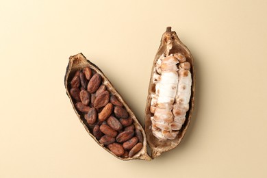 Photo of Cocoa pods with beans on beige background, top view