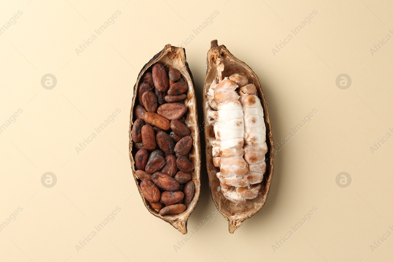 Photo of Cocoa pods with beans on beige background, top view