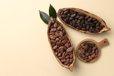 Photo of Cocoa pods with beans on beige background, flat lay. Space for text