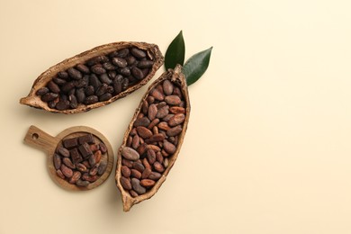 Photo of Cocoa pods with beans on beige background, flat lay. Space for text