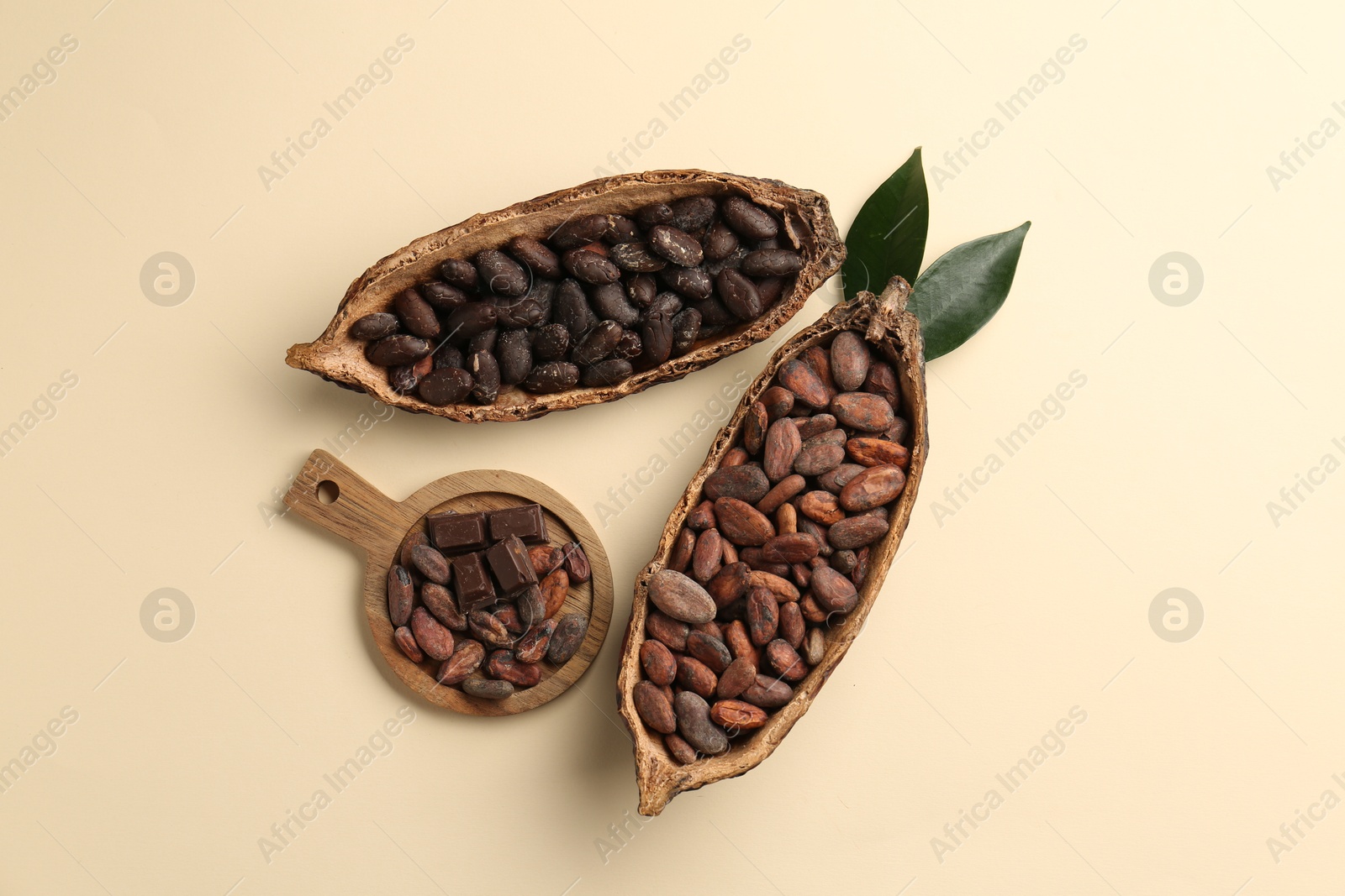 Photo of Cocoa pods with beans on beige background, flat lay