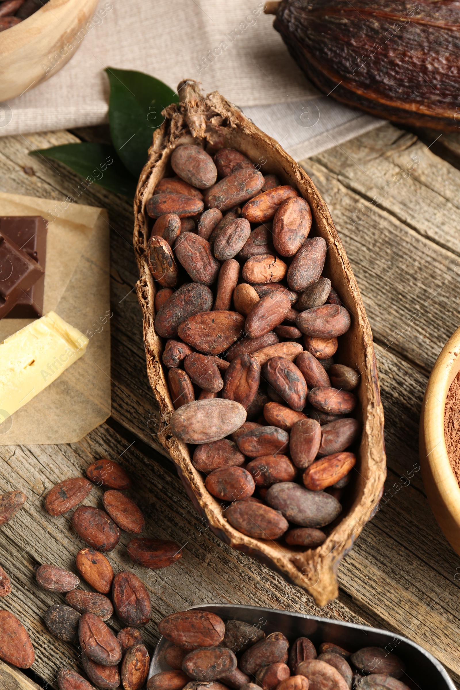 Photo of Cocoa pod with beans and butter on wooden table