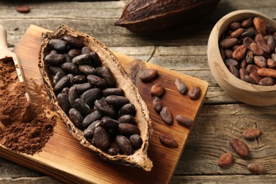 Photo of Cocoa pods with beans and powder on wooden table