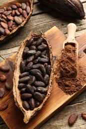 Photo of Cocoa pods with beans and powder on wooden table