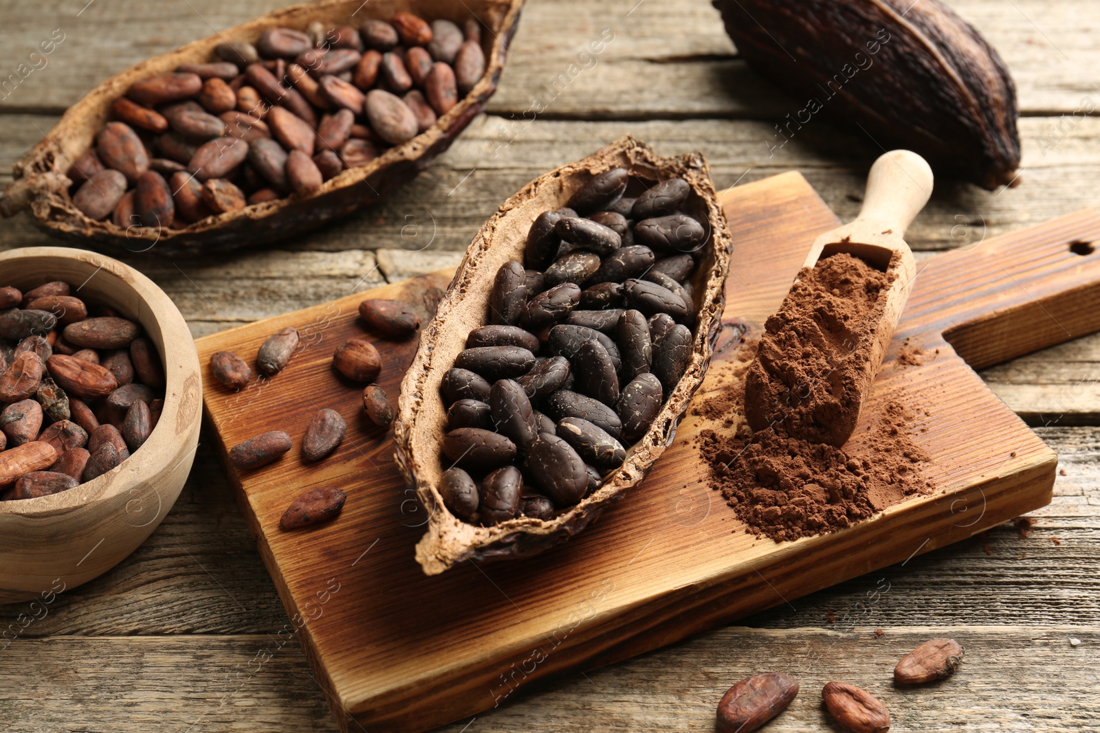 Photo of Cocoa pods with beans and powder on wooden table