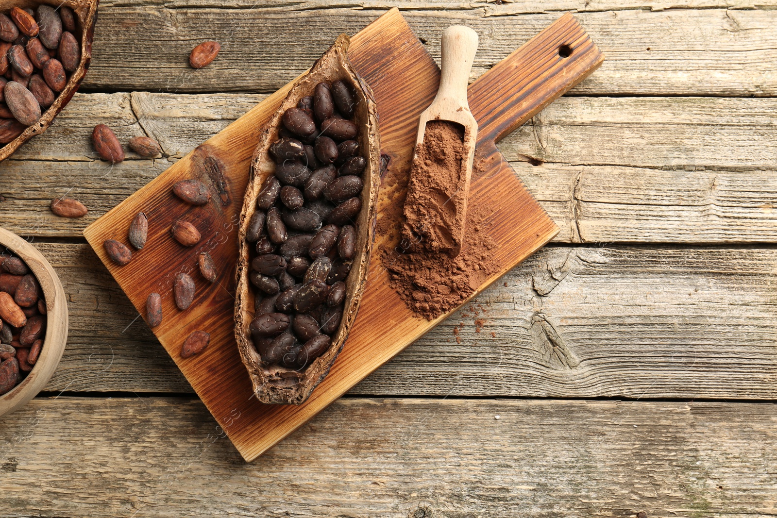 Photo of Cocoa pod with beans and powder on wooden table, flat lay. Space for text