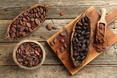 Cocoa pods with beans and powder on wooden table, flat lay