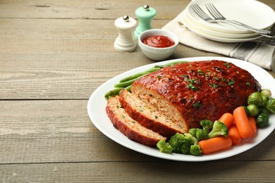 Photo of Delicious baked turkey meatloaf with vegetables served on wooden table, closeup. Space for text