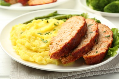 Photo of Delicious baked turkey meatloaf with mashed potato served on table, closeup