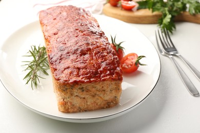 Photo of Delicious baked turkey meatloaf, rosemary, cherry tomatoes and parsley on white table, closeup