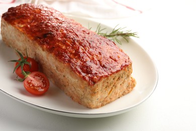 Delicious baked turkey meatloaf, rosemary and cherry tomatoes on white table, closeup