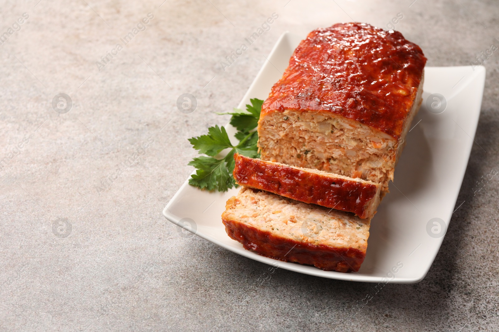 Photo of Delicious baked turkey meatloaf with parsley on grey table, closeup. Space for text