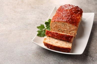 Delicious baked turkey meatloaf with parsley on grey table, closeup. Space for text